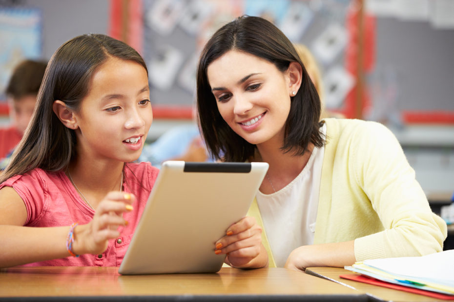 Pupils In Class Using Digital Tablet With Teacher